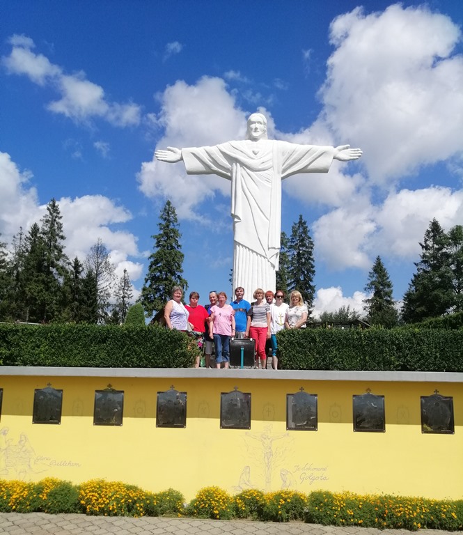 Socha Ježiša Krista na vrchu Grapa, pod sochou skupina pózujúcich výletníkov