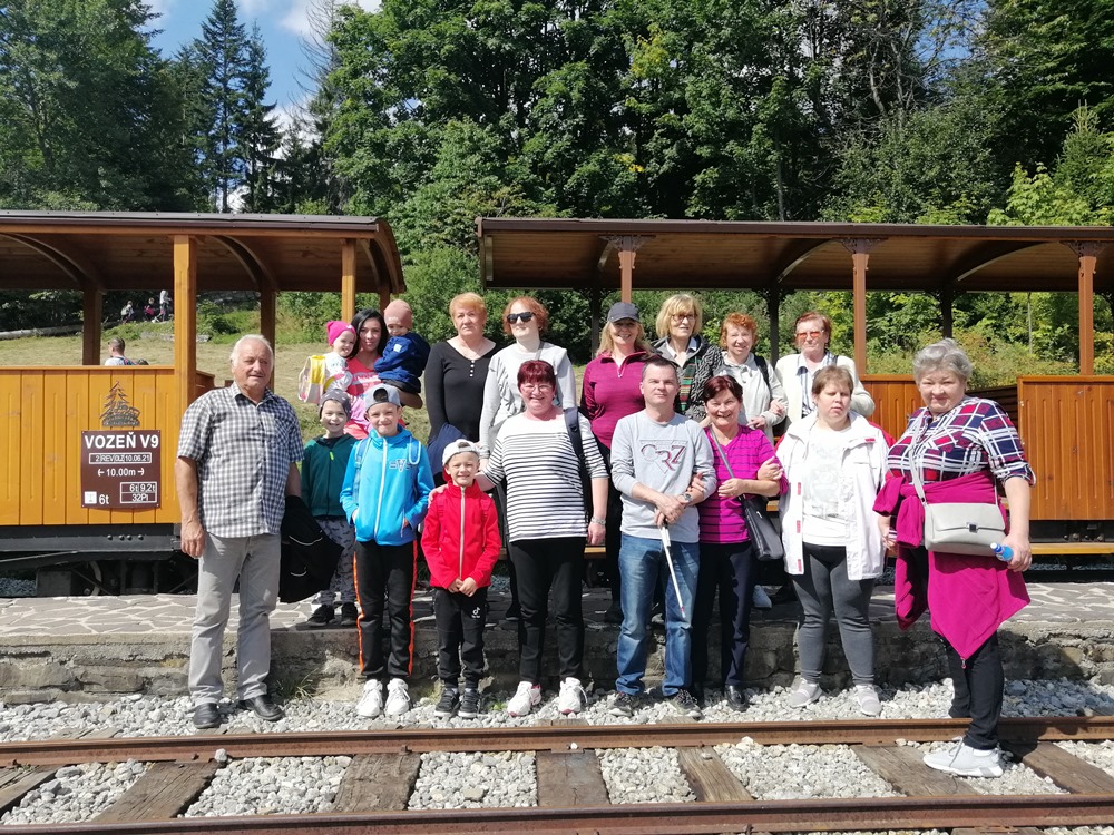 Členovia ZO stoja pred otvorenými vagónmi železničky