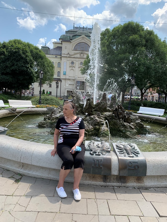 žena sediaca pri spievajúcej fontáne v Košiciach