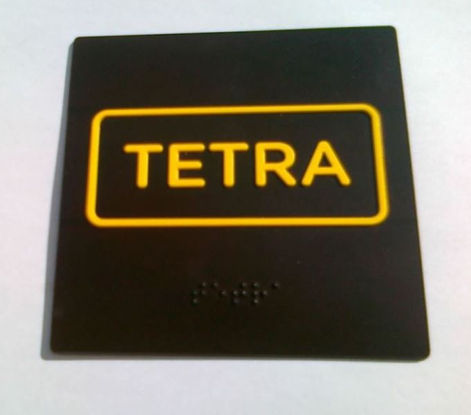 Štítok na kontajner určený na tetrapakové obaly s nápisom Tetra a braillovým popisom.