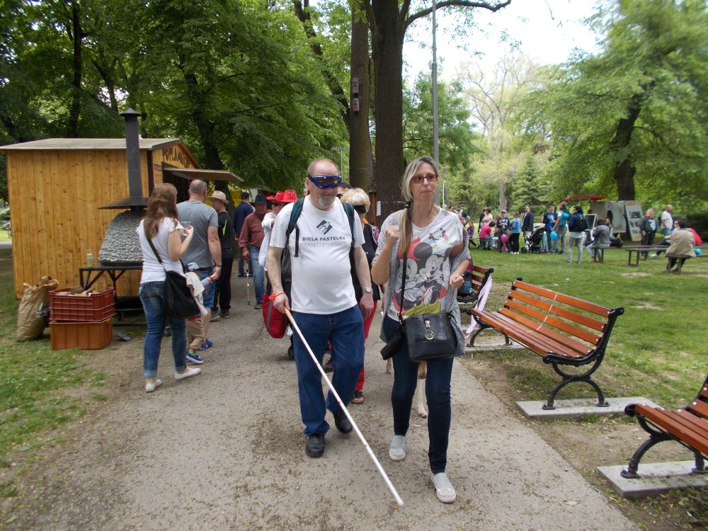Na fotografii je Josef Zbranek s bielou palicou v ruke kráča na čele zástupu ľudí, ktorí formujú "slepú stonožku". Strana 16