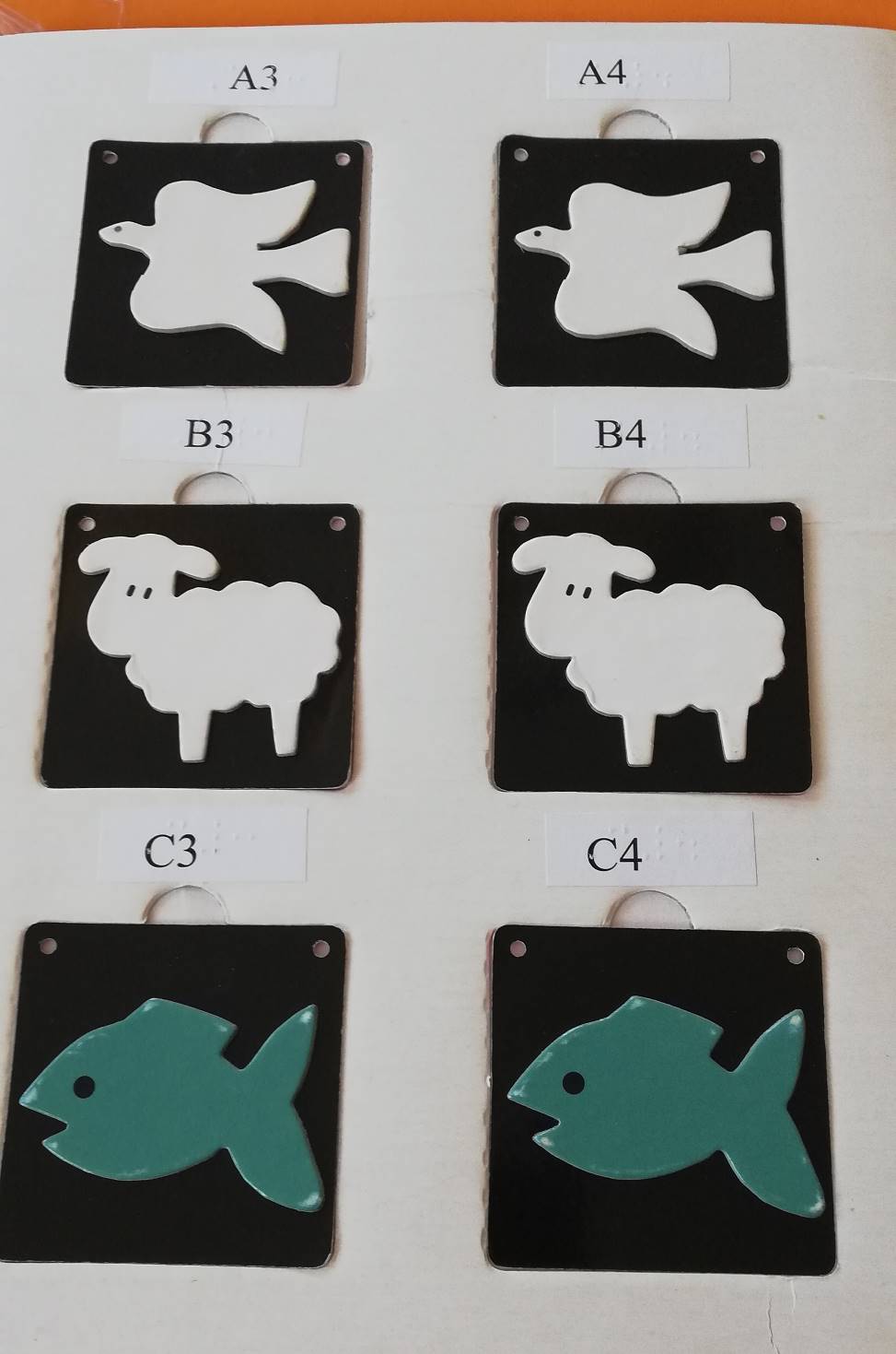 reliéfne pexeso z dielne Slovenskej biblickej spoločnosti, na kartičkách je dvojica holubíc, ovečiek a rýb