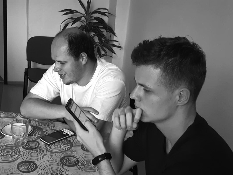 dvaja muži skúšajú aplikácie na mobilných telefónoch