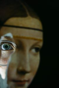 Časť tváre z obrazu Dáma s hranostajom, ktorá má však doplnené oko hľadiace do objektívu. Montáž vytvára dojem, že škúli.