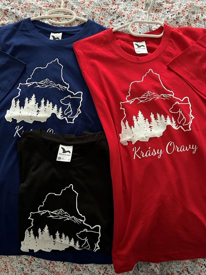 Tri tričká - modré, červené a čierne s obrázkom oravskej prírody a nápisom Krásy Oravy.  