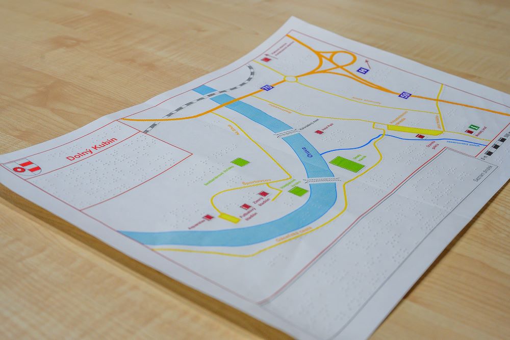 Na fotografii je mapa užšieho centra Dolného Kubína. Je vidieť modrú rieku a žlté cesty. Na mape sa nachádzajú aj popisky v braili. 
