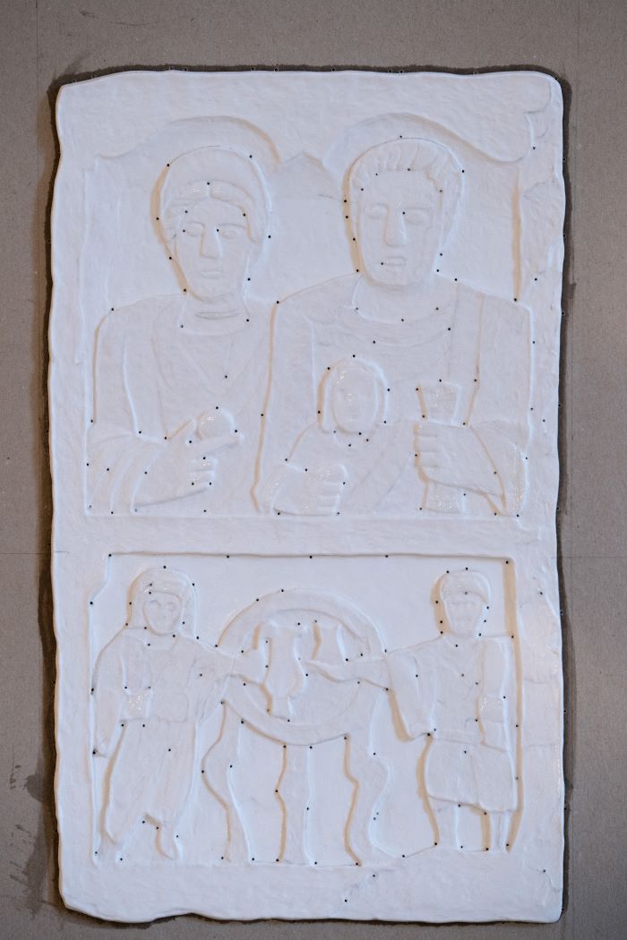 Záber na matricu k obrázku náhrobného kameňa rímskej rodiny. V hornej časti sú rodičia, v dolnej dve deti.