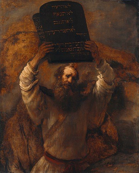 Na fotografii je obraz, na ktorom je Mojžiš s hustou bradou v bielej košeli. Nad hlavou drží jednu z tabúľ zákona.