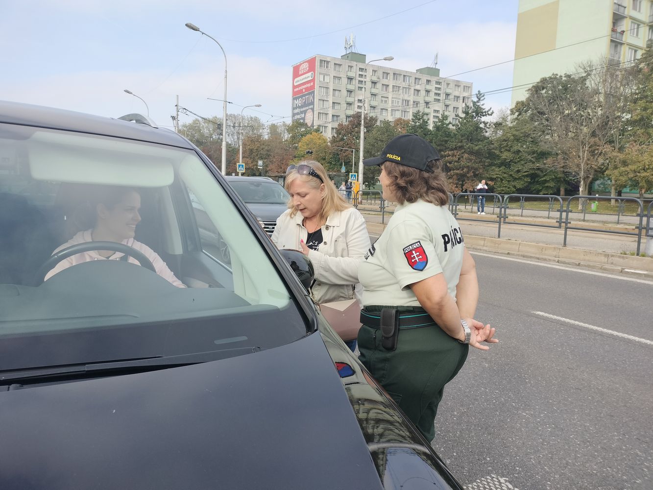 Na fotografii sú tri ženy: vodička auta, policajtka a informátorka. 